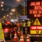 Petugas polisi menutup jalur menuju Kawasan Puncak di Tugu Lampu Gentur Cianjur saat malam pergantian Tahun Baru 2026 untuk mengantisipasi kemacetan. (Posnews/Humas Polda Jabar)