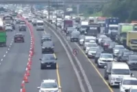 Petugas kepolisian mengatur buka-tutup Rest Area KM 57 Tol Jakarta-Cikampek saat antrean kendaraan meningkat pada libur Natal dan Tahun Baru 2025. (Posnews/Jasa Marga)