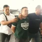 Tersangka Samuel Ardi Kristanto dijemput tim penyidik Subdit Renakta Polda Jawa Timur. (Posnews/Polda Jatim)
