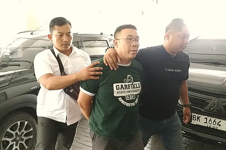 Tersangka Samuel Ardi Kristanto dijemput tim penyidik Subdit Renakta Polda Jawa Timur. (Posnews/Polda Jatim)