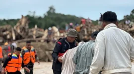 Petugas SAR mengevakuasi warga di lokasi banjir besar di Sumatera, air meluap dan rumah-rumah rusak parah. (Posnews/Ist)