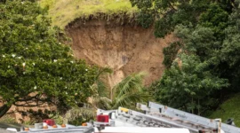 Liburan berubah jadi tragedi. Bukit runtuh menimpa perkemahan di Mount Maunganui, sementara banjir bandang memaksa warga menyelamatkan diri ke atap rumah. Dok: Bloomberg.