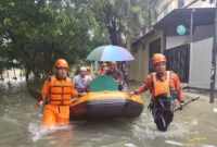 Petugas BPBD Jakarta Utara mengevakuasi warga terdampak banjir Kapuk Muara menggunakan perahu karet akibat hujan deras. (Posnews/MR)
