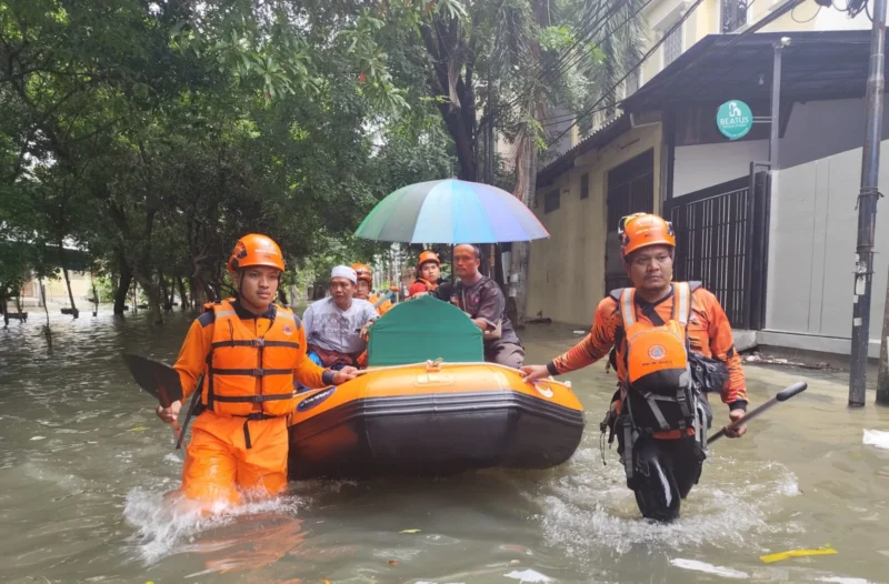 Petugas BPBD Jakarta Utara mengevakuasi warga terdampak banjir Kapuk Muara menggunakan perahu karet akibat hujan deras. (Posnews/MR)
