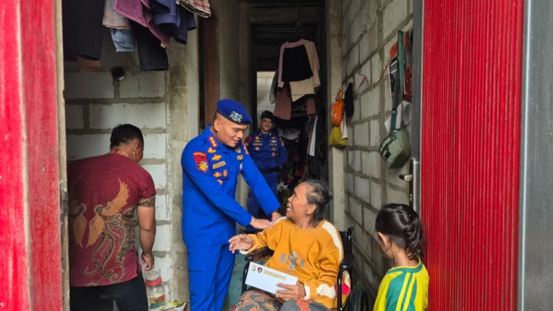 Direktur Ditpolairud Polda Metro Jaya Kombes Pol Mustofa menyerahkan kursi roda kepada warga pesisir Kali Adem, Jakarta Utara dalam kegiatan bakti kesehatan. (Posnews/Ist)