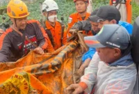 Petugas Basarnas mengevakuasi kantong body part korban longsor di Kampung Pasir Kuning, Cisarua, Bandung Barat, Jawa Barat. (Posnews/Ist)