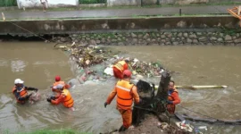 Pasukan Oranye membersihkan sampah di lokasi rawan banjir Jakarta untuk antisipasi curah hujan tinggi. (Posnews/Ist)