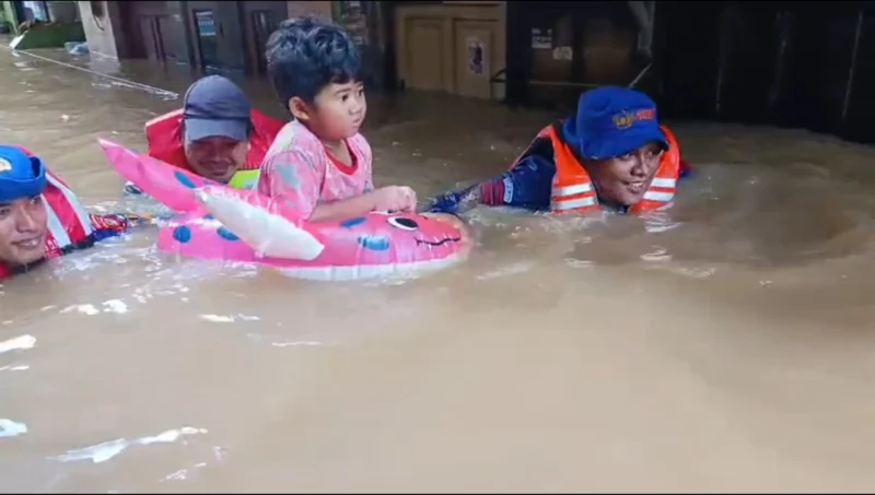 Personel Siaga SAR Ditpolairud Polda Metro Jaya mengevakuasi anak kecil terdampak banjir setinggi dua meter di Kebon Pala, Jakarta Timur. (Posnews/Ist)