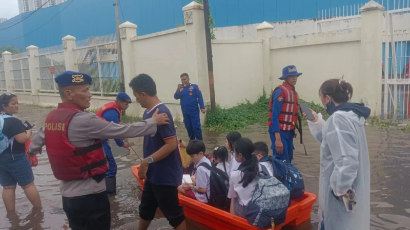 Personel Tim SAR Ditpolairud Polda Metro Jaya mengevakuasi warga saat banjir di Jakarta. (Posnews/Ist)