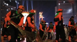 Petugas Pasukan Oranye DLH DKI Jakarta membersihkan sampah sisa perayaan Malam Tahun Baru 2026 di kawasan Bundaran HI, Jakarta. (Posnews/Dinas LH DKI)