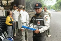 Petugas Satpol PP Kelapa Gading mengamankan puluhan pelat nomor kendaraan yang dipungli tukang tambal ban saat banjir di Jakarta Utara. (Posnews/MR)