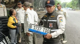 Petugas Satpol PP Kelapa Gading mengamankan puluhan pelat nomor kendaraan yang dipungli tukang tambal ban saat banjir di Jakarta Utara. (Posnews/MR)