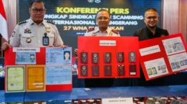 Plt Direktur Jenderal Imigrasi Yuldi Yusman menunjukkan baran bukti jaringan Love Scamming AI, 27 WN China ditangkap Imigrasi. (Posnews/Ist)