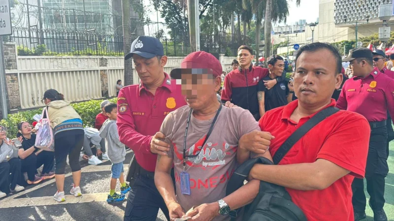 Petugas Ditpamobvit Polda Metro Jaya mengamankan dua terduga copet saat Car Free Day di Bundaran HI Jakarta.(Posnews/Ist)