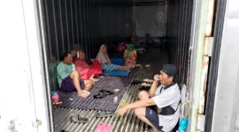 Warga Kampung Sepatan mengungsi di dalam boks container saat banjir merendam permukiman RT 18 RW 05 Kelurahan Rorotan, Cilincing, Jakarta Utara. (Posnews/MR)