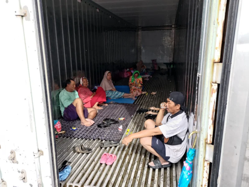 Warga Kampung Sepatan mengungsi di dalam boks container saat banjir merendam permukiman RT 18 RW 05 Kelurahan Rorotan, Cilincing, Jakarta Utara. (Posnews/MR)