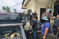 Personel Satgas Damai Cartenz 2026 mengawal tiga tersangka DPO KKB Yahukimo saat tiba di Jayapura untuk menjalani proses hukum di Polda Papua, Senin (23/2/2026). (Posnews/Ist)