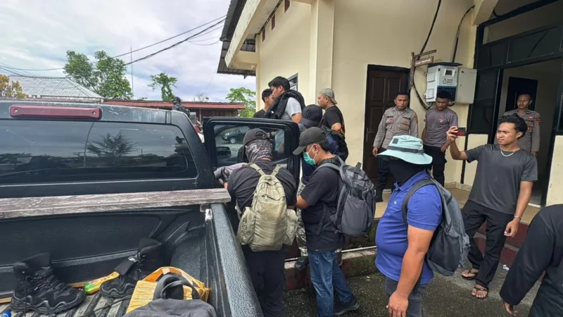 Personel Satgas Damai Cartenz 2026 mengawal tiga tersangka DPO KKB Yahukimo saat tiba di Jayapura untuk menjalani proses hukum di Polda Papua, Senin (23/2/2026). (Posnews/Ist)