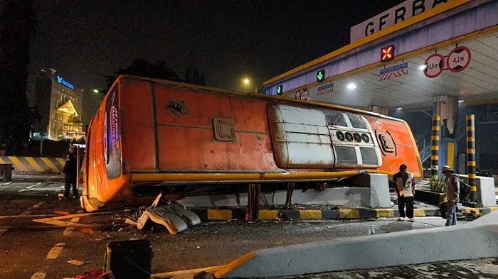 Bus pariwisata ringsek di Gerbang Tol Waru Utama Surabaya setelah diduga mengalami rem blong. Posnews/Ist)