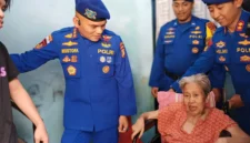 Direktur Polairud Polda Metro Jaya, Kombes Pol Mustofa menyerahkan kursi roda dan paket sembako kepada lansia penderita stroke di Muara Angke, Penjaringan, Jakarta Utara.