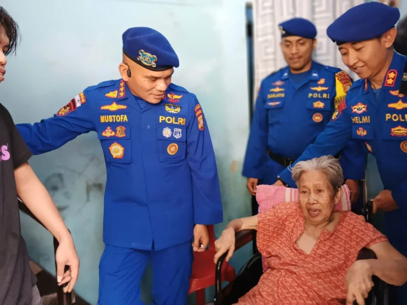 Direktur Polairud Polda Metro Jaya, Kombes Pol Mustofa menyerahkan kursi roda dan paket sembako kepada lansia penderita stroke di Muara Angke, Penjaringan, Jakarta Utara.
