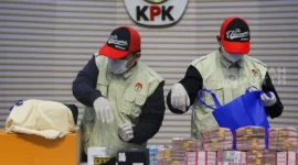 Petugas KPK menunjukkan barang bukti uang dan logam mulia hasil OTT kasus suap importasi Bea Cukai di Gedung Merah Putih KPK, Jakarta. (Posnews/KPK)