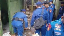 Personel Ditpolairud Polda Metro Jaya bersama warga membersihkan lumpur sisa banjir di permukiman Kebon Pala Kampung Melayu Jakarta Timur, 22 Maret 2026. (Posnews/ist)