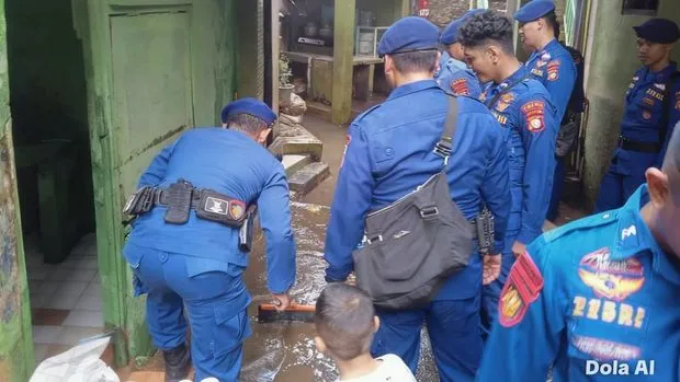 Personel Ditpolairud Polda Metro Jaya bersama warga membersihkan lumpur sisa banjir di permukiman Kebon Pala Kampung Melayu Jakarta Timur, 22 Maret 2026. (Posnews/ist)