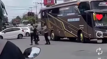 Bus pariwisata menabrak anggota polisi saat razia lalu lintas di Simpang Lima Tugu Pendekar Madiun hingga korban mengalami patah kaki. (Posnews/Ist)