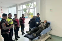 Petugas kepolisian mengevakuasi pengendara lansia yang pingsan di kawasan Gunung Mas Bogor saat Operasi Ketupat 2026 berlangsung. (Posnews/Ist)