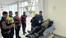 Petugas kepolisian mengevakuasi pengendara lansia yang pingsan di kawasan Gunung Mas Bogor saat Operasi Ketupat 2026 berlangsung. (Posnews/Ist)