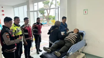 Petugas kepolisian mengevakuasi pengendara lansia yang pingsan di kawasan Gunung Mas Bogor saat Operasi Ketupat 2026 berlangsung. (Posnews/Ist)