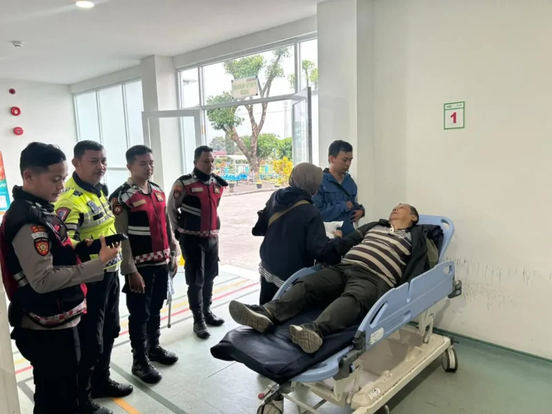 Petugas kepolisian mengevakuasi pengendara lansia yang pingsan di kawasan Gunung Mas Bogor saat Operasi Ketupat 2026 berlangsung. (Posnews/Ist)