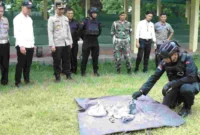 Petugas Densus 88 menunjukkan barang bukti bubuk petasan dan handphone usai menangkap dua pemuda di Surabaya terkait penjualan mesiu ilegal. (Posnews/Ist)