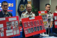 Petugas Imigrasi Bogor menunjukkan barang bukti sindikat scam online WN Jepang di Sentul City berupa seragam polisi palsu dan perangkat elektronik. (Posnews/Ist)