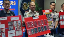 Petugas Imigrasi Bogor menunjukkan barang bukti sindikat scam online WN Jepang di Sentul City berupa seragam polisi palsu dan perangkat elektronik. (Posnews/Ist)