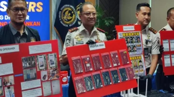 Petugas Imigrasi Bogor menunjukkan barang bukti sindikat scam online WN Jepang di Sentul City berupa seragam polisi palsu dan perangkat elektronik. (Posnews/Ist)