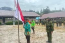 Tiga mantan anggota OPM mencium bendera Merah Putih saat ikrar setia NKRI di Distrik Sinak Papua Tengah. (Posnews/ist)