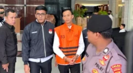 Ajudan eks Gubernur Riau Marjani memakai rompi tahanan KPK saat digiring petugas di Gedung Merah Putih usai ditahan terkait kasus pemerasan dan aliran dana “jatah preman”. (Posnews/Net)