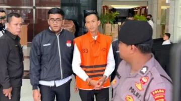 Ajudan eks Gubernur Riau Marjani memakai rompi tahanan KPK saat digiring petugas di Gedung Merah Putih usai ditahan terkait kasus pemerasan dan aliran dana “jatah preman”. (Posnews/Net)