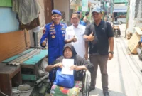 Direktur Polairud Polda Metro Jaya, Kombes Pol Mustofa menyerahkan kursi roda kepada warga pesisir Muara Angke yang menderita stroke. (Posnews/ist)