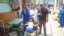 Direktur Polairud Polda Metro Jaya, Kombes Pol Mustofa menyerahkan kursi roda kepada warga pesisir Muara Angke yang menderita stroke. (Posnews/ist)