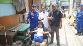 Direktur Polairud Polda Metro Jaya, Kombes Pol Mustofa menyerahkan kursi roda kepada warga pesisir Muara Angke yang menderita stroke. (Posnews/ist)