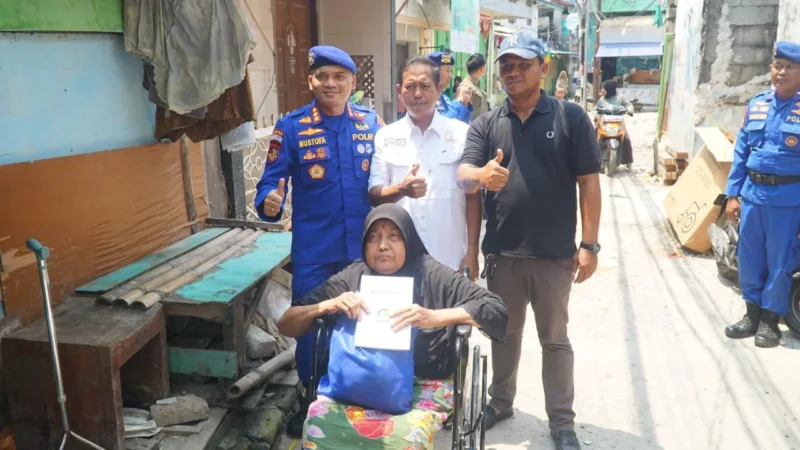 Direktur Polairud Polda Metro Jaya, Kombes Pol Mustofa menyerahkan kursi roda kepada warga pesisir Muara Angke yang menderita stroke. (Posnews/ist)