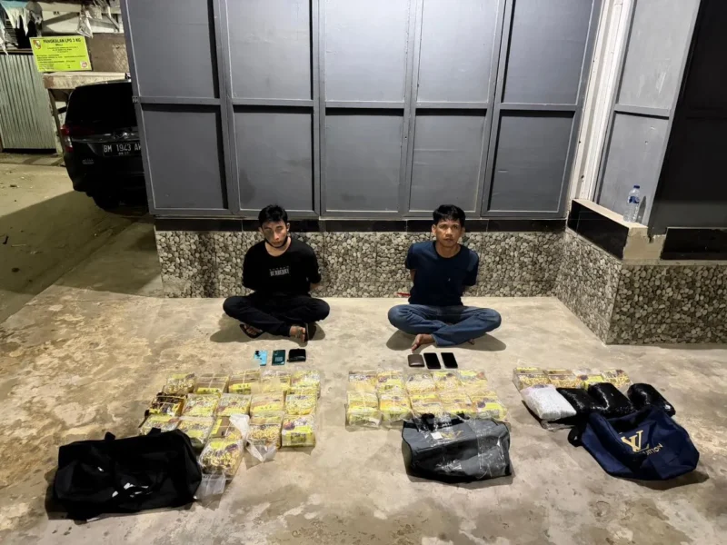 Dua tersangka Bersama barang bukti 30 kilogram sabu dan ribuan pil ekstasi hasil pengungkapan jaringan narkoba internasional oleh Bareskrim Polri di Pekanbaru, Riau. (Posnews/Ist)