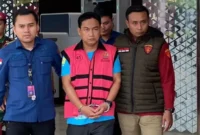 Ketua Ombudsman RI Hery Susanto mengenakan rompi tahanan saat digiring petugas Kejaksaan Agung. (Posnews/Kejagung)
