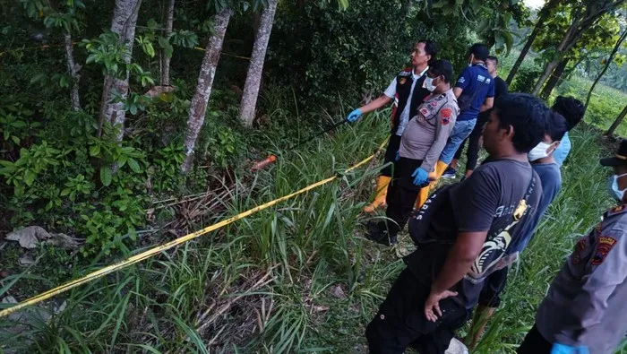 Petugas polisi mengevakuasi jasad remaja yang ditemukan terkubur dangkal dengan kepala terikat di Desa Gandrirojo, Rembang. (Posnews/Ist)