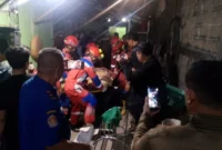 Petugas Damkar mengevakuasi korban dari reruntuhan tembok bangunan yang ambruk di kawasan Koja Jakarta Utara. (Posnews/MR)