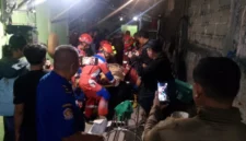 Petugas Damkar mengevakuasi korban dari reruntuhan tembok bangunan yang ambruk di kawasan Koja Jakarta Utara. (Posnews/MR)