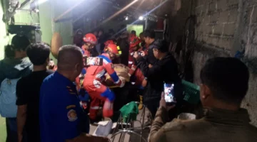 Petugas Damkar mengevakuasi korban dari reruntuhan tembok bangunan yang ambruk di kawasan Koja Jakarta Utara. (Posnews/MR)